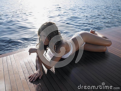 Sensuous Woman Sunbathing On Yacht's Floorboard Stock Photo