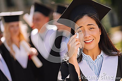 Sentimental girl crying during her graduation ceremony. Stock Photo