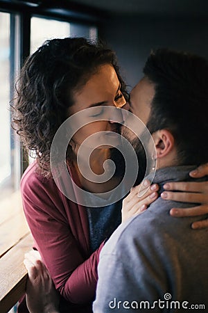 Sentimental happy couple in love near a window in a cafe Stock Photo