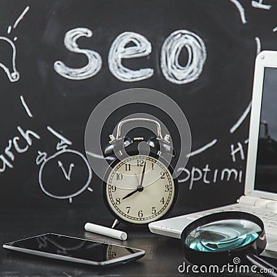 SEO Search engine optimization concept Magnifying glass, clock, smartphone on a black background with an inscription SEO Close up Stock Photo