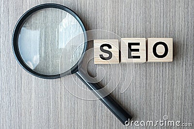 SEO Search Engine Optimization text wooden cubes and magnifying glass on wood table background. Idea, Vision, Strategy, Analysis Stock Photo