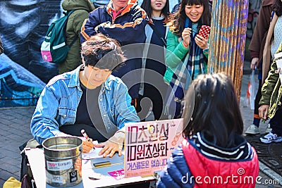 Seoul, Korea - March 7, 2015 : street artist draws a portrait caricature of a little girl at Free Market Editorial Stock Photo