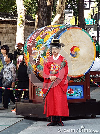 A man in front of a large drum at the Changing of the Royal Guard ceremony at the main entrance to Deoksugung Palace in Seoul Editorial Stock Photo