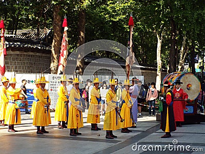 Musicians in yellow uniform in front of a large drum at the changing of the Royal Guard ceremony at Deoksugung Palace in Seoul Editorial Stock Photo