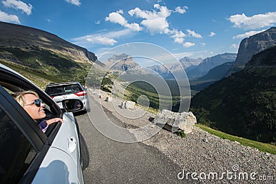 SWIFTCURRENT, MT: Blonde female admires the beautiful mountain scenery along Going to the Sun Road in Montana from Editorial Stock Photo