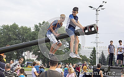 September 9, 2018 Minsk, Belarus. Victory Park. Two teenagers sit on the muzzle of a tank during Editorial Stock Photo