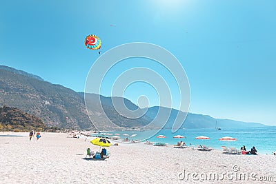 People resting and swimming on parasols and sunbeds on a popular public beach in resort town Editorial Stock Photo