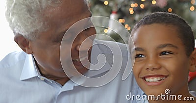 Sequenza del movimento lento del ragazzo che si siede sul sofà con il padre ed il nonno al tempo di Natale Sequenza del movimento lento del ragazzo che si siede sul sofà con il padre ed il nonno al tempo di Natale