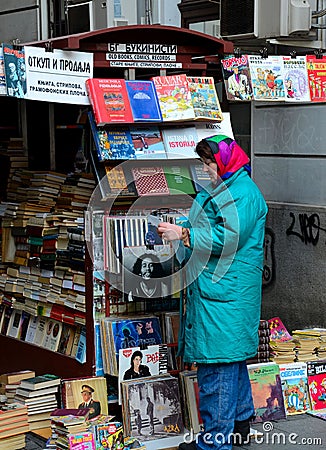 Serbian woman attends to outdoor magazine books & vinyl stall Belgrade Serbia Editorial Stock Photo