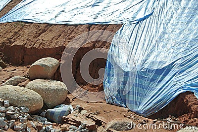 The plastic sheet is spread over the surface of the slope to prevent erosion. Editorial Stock Photo