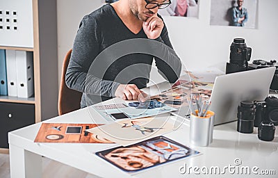 Serious photographer looking at printed images Stock Photo