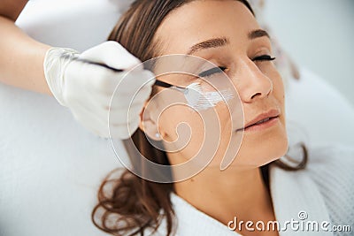 Beautician applying a nutrient mask to the patient face Stock Photo