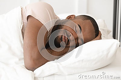 Serene calm young black man sleeping well alone in bed Stock Photo