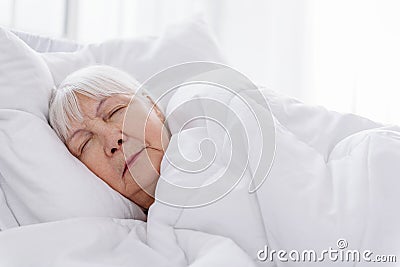 Serene old woman keeping to bed in hospital Stock Photo