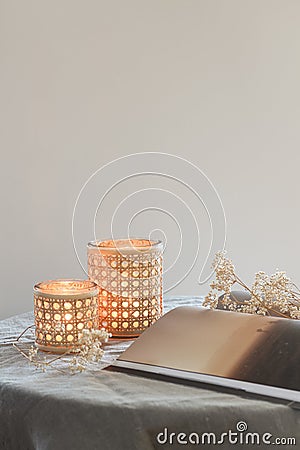Serene scene in neutral tones with burning candles and some flowers Stock Photo
