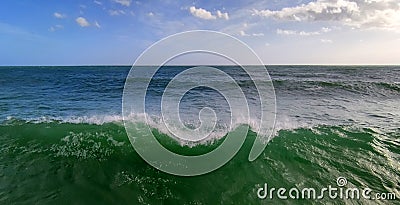 Serene sea panorama with big green wave in the foreground, tsunami Stock Photo