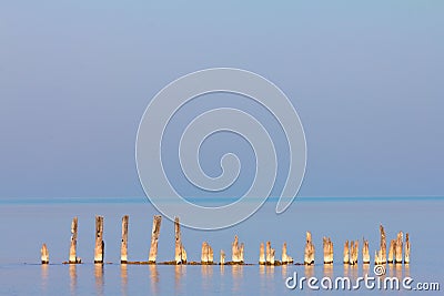 Broken, Spiked Poles Emerging from Ocean Waters Stock Photo