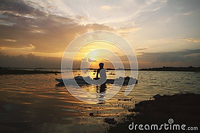 Serene sunset in the lake and boatman Stock Photo