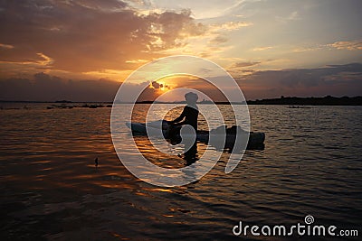 Serene sunset in the lake and boatman Stock Photo