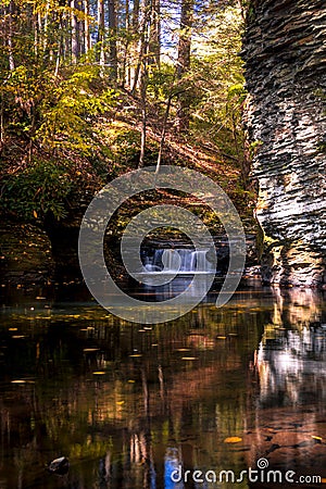 Serene waterfall reflects in the calm water and gorge Stock Photo