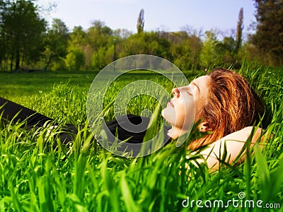 Serene woman relaxing outdoor in fresh grass Stock Photo