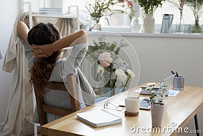 Serene young businesswoman relaxing in modern stylish creative workplace. Stock Photo