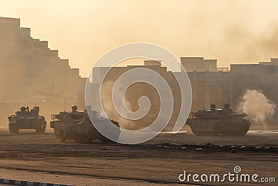 Army tanks shooting and driving in the desert town in war and military conflict. Military concept of war and explosions Stock Photo