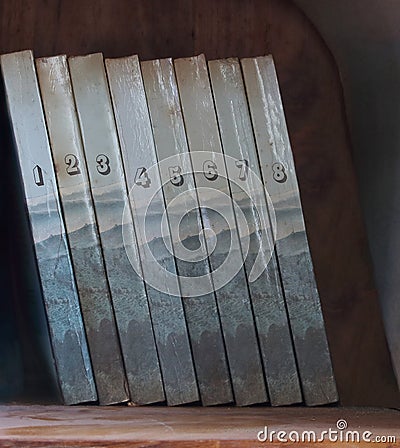 Eight volumes of old dusty books on bookshelf Stock Photo