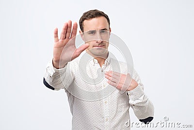 Seriou young man showing stop gesture. Social distance concept Stock Photo