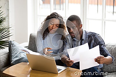 Serious African American couple discussing paper documents Stock Photo