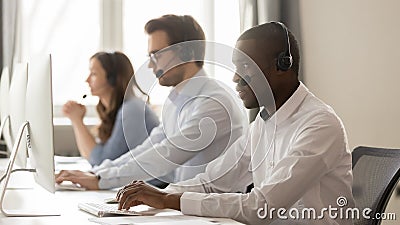 Serious african call center agent in headset working on computer Stock Photo