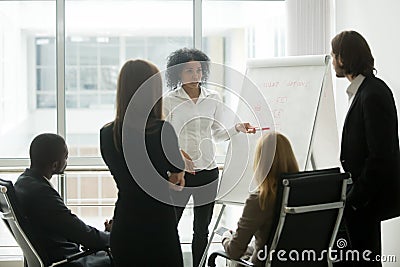 Serious african female leader gives presentation at sales team m Stock Photo