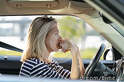 Serious anxious woman driving car. Female driver of middle age pensive sad waiting in traffic jam Stock Photo