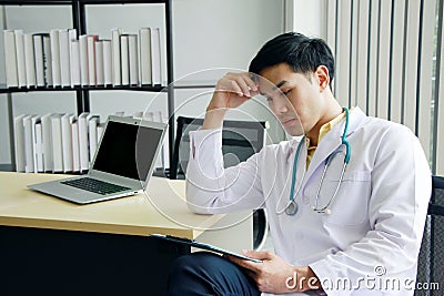 Serious Asian Psychiatrist MD man is researching with laptop for mental health problems in clinical depression people life. Stock Photo