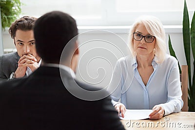 Serious attentive senior hr listening to candidate at job interv Stock Photo