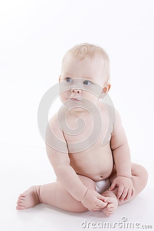 Serious baby-boy in a diaper sitting on the floor Stock Photo