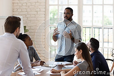 Serious black manager talk to diverse staff people at meeting Stock Photo