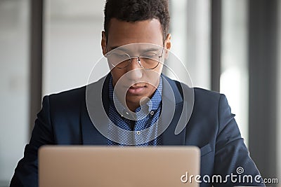 Serious black employee working on laptop consulting client Stock Photo