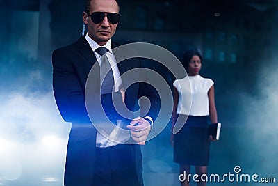 Serious bodyguard in suit, sunglasses and earpiece Stock Photo