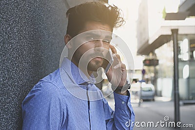 Business man standing in city street and talking on mobi Stock Photo