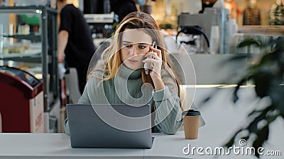 Serious business woman freelance manager worker student sitting at table with laptop answering call talking on phone Stock Photo