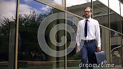 Serious businessman with briefcase going to work, purposeful and successful Stock Photo