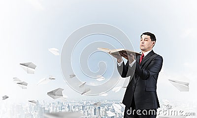 Serious businessman holding open old book Stock Photo