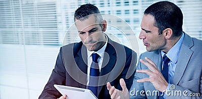 Serious businessmen analyzing documents on their tablet Stock Photo