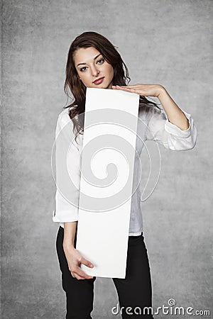 Serious businesswoman holds a place for your advertisement Stock Photo