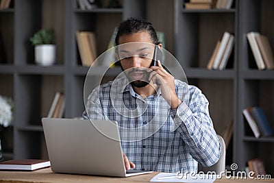 Serious busy African business professional guy working at laptop Stock Photo