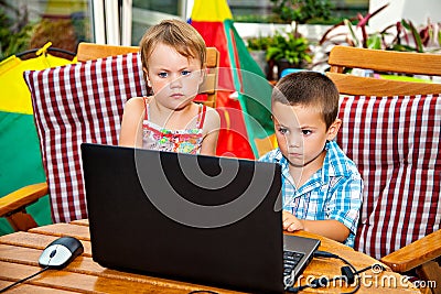 Serious children with laptop Stock Photo