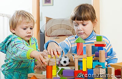 Serious children playing with wooden blocks Stock Photo