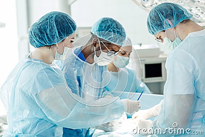 Serious clever surgeons work in an emergency room Stock Photo