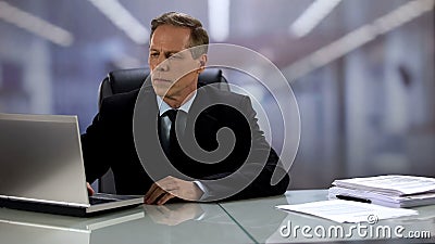 Serious company boss working at laptop, answering e-mail, professionalism Stock Photo